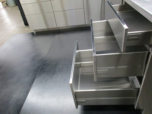 A closer view of neatly designed stainless steel cabinet with drawers.
